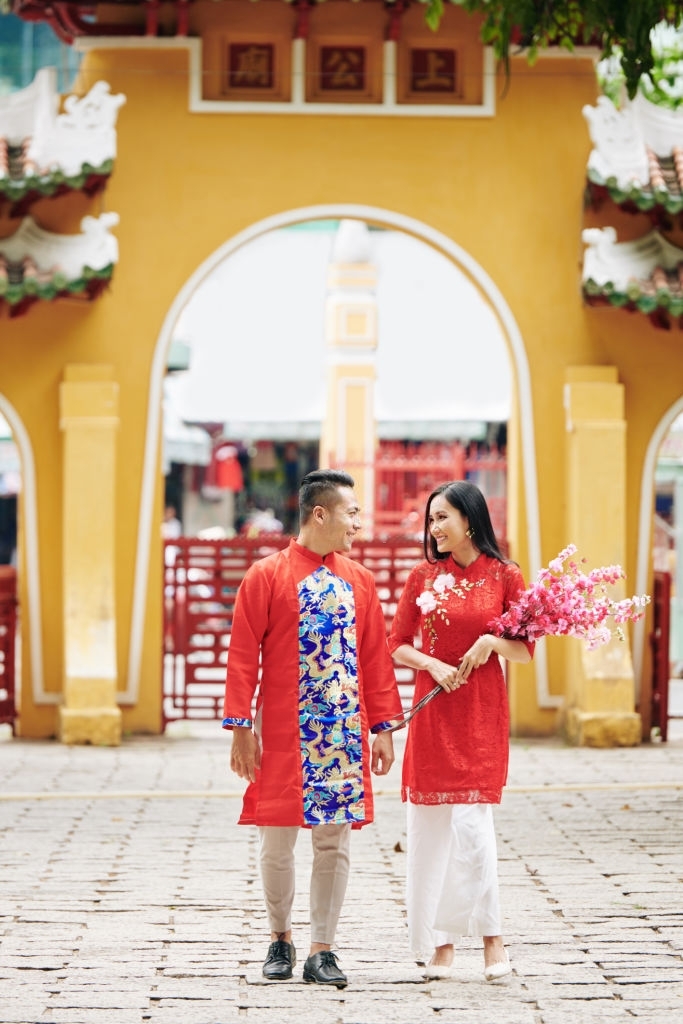 Bạn có muốn thưởng thức những khoảnh khắc Tết đẹp đầy ngọt ngào và lãng mạn? Hãy xem bức ảnh chụp cặp đôi tình nhân trong trang phục truyền thống Việt Nam với nụ cười tươi tắn và giữ tay nhau. Đó chắc chắn sẽ là hình ảnh đáng nhớ để chào đón năm mới.